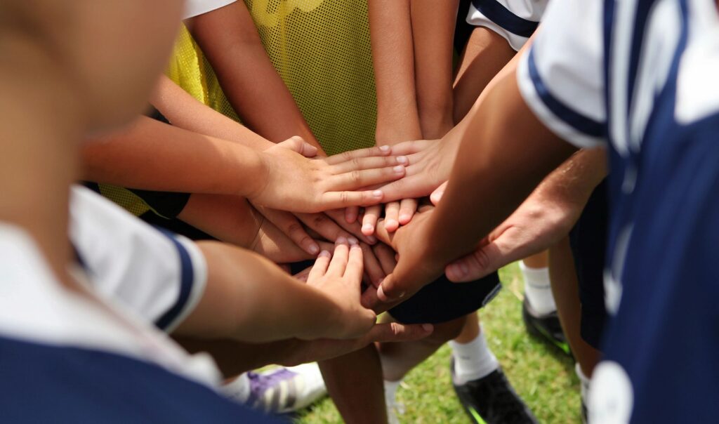 Hands in for a soccer team cheer.