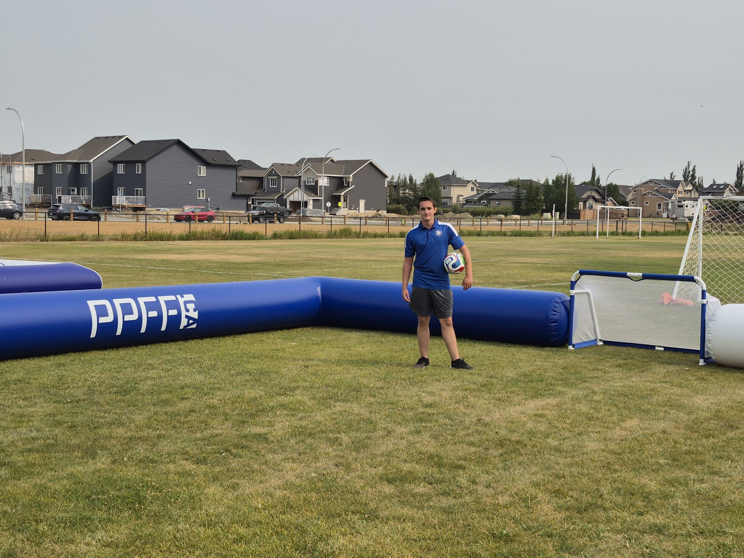 A player with a ball standing within a PPFF 3v3 Soccer field